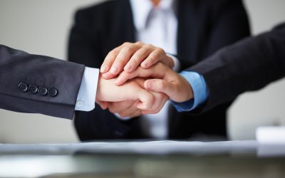 Image of business partners hands on top of each other symbolizing companionship and unity